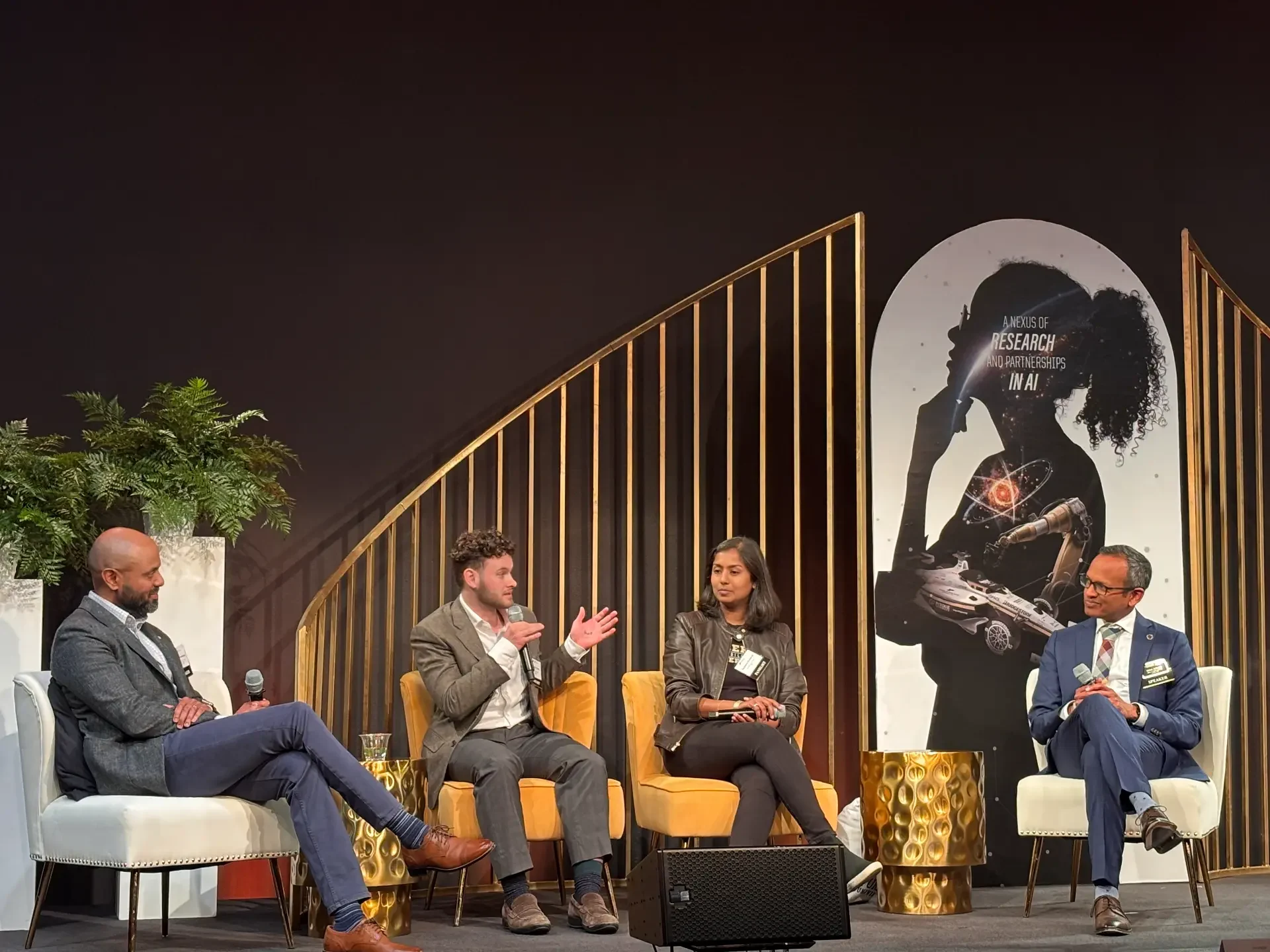 Four panelists seated in armchairs on stage at the Purdue Engineering Tech Summit, with a backdrop reading A Nexus of Research and Partnerships in AI